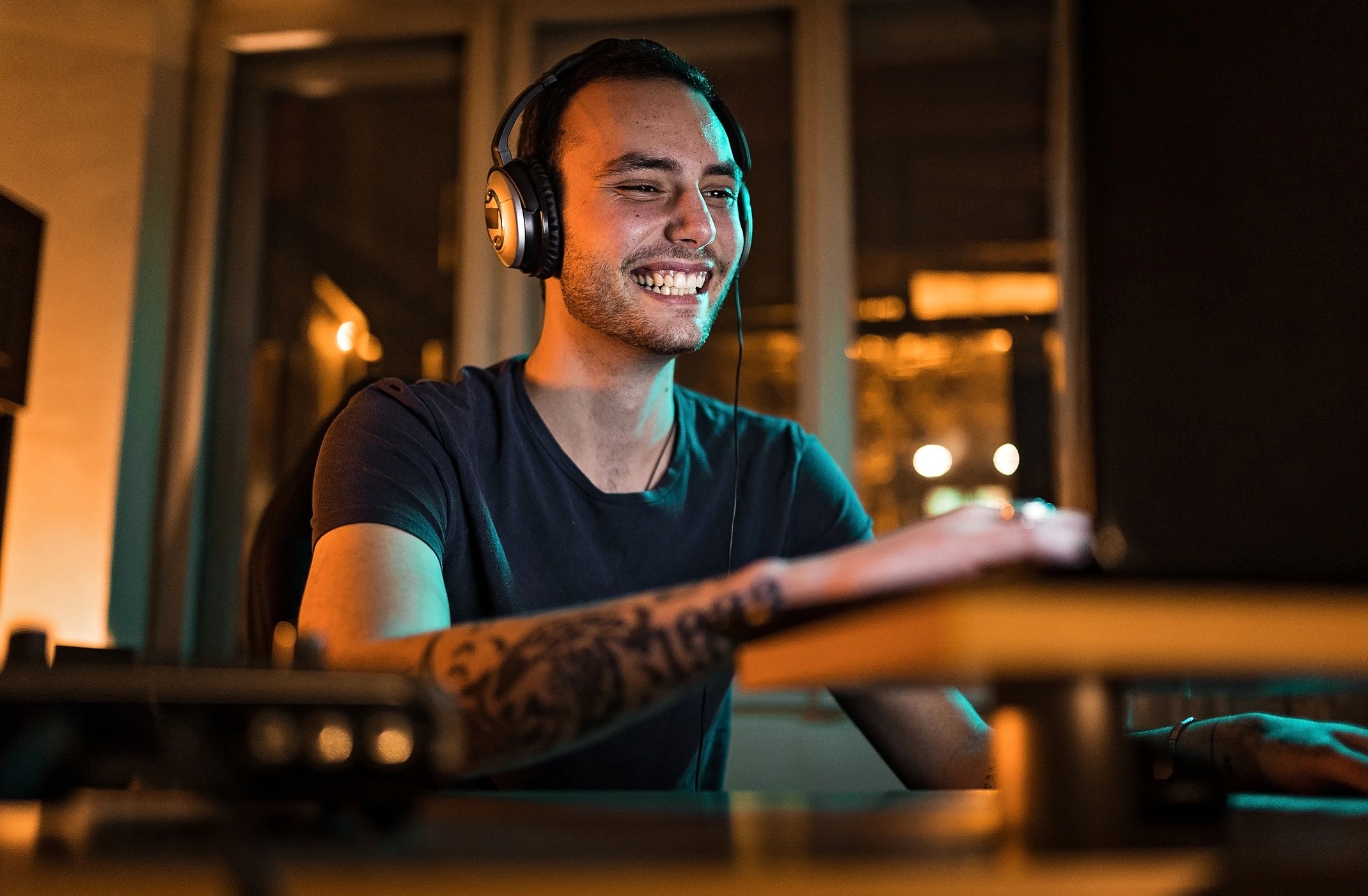 Producer working on a laptop in a home studio at night